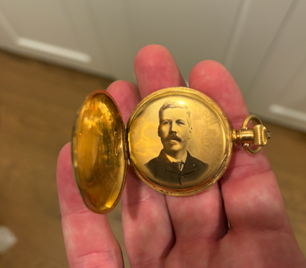 A portrait of William Whyte inside the gold-coloured pocket watch case.